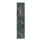A table runner with a floral William Morris & Co pattern, featuring green leaves and pink flowers with a fox, dear and rabbit.