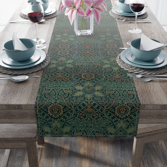 A green table runner with a floral pattern inspired by William Morris, displayed on a dining table with dishes and cutlery.