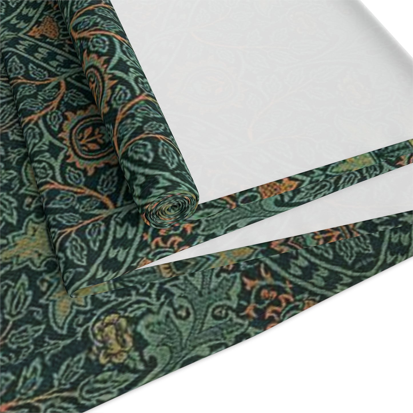 A green table runner with a floral pattern inspired by William Morris, displayed on a dining table with dishes and cutlery.