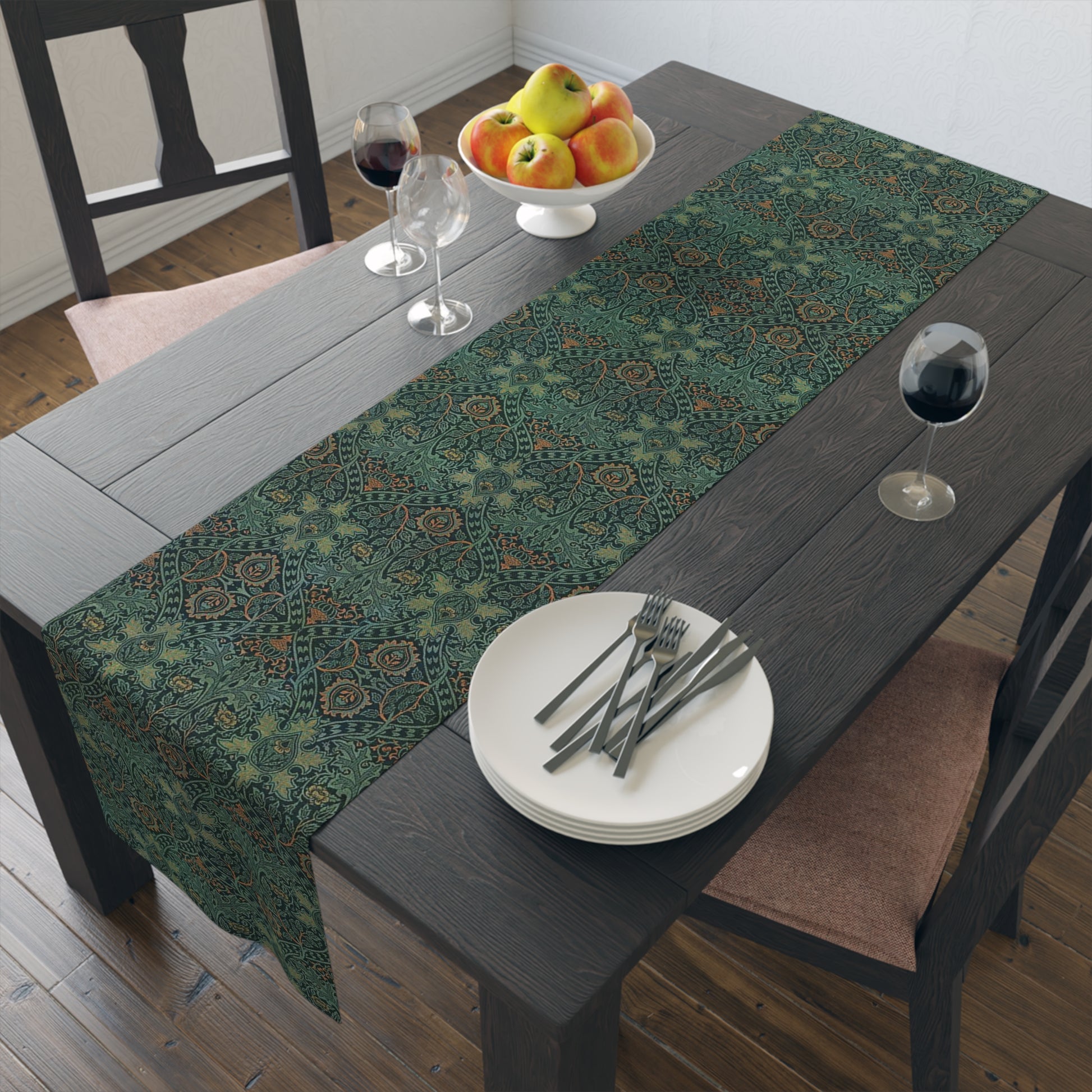 A green table runner with a floral pattern inspired by William Morris, displayed on a dining table with dishes and cutlery.