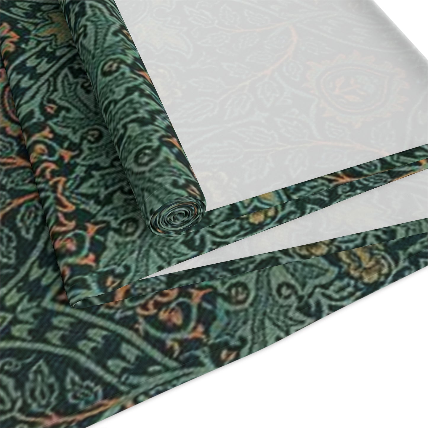 A green table runner with a floral pattern inspired by William Morris, displayed on a dining table with dishes and cutlery.