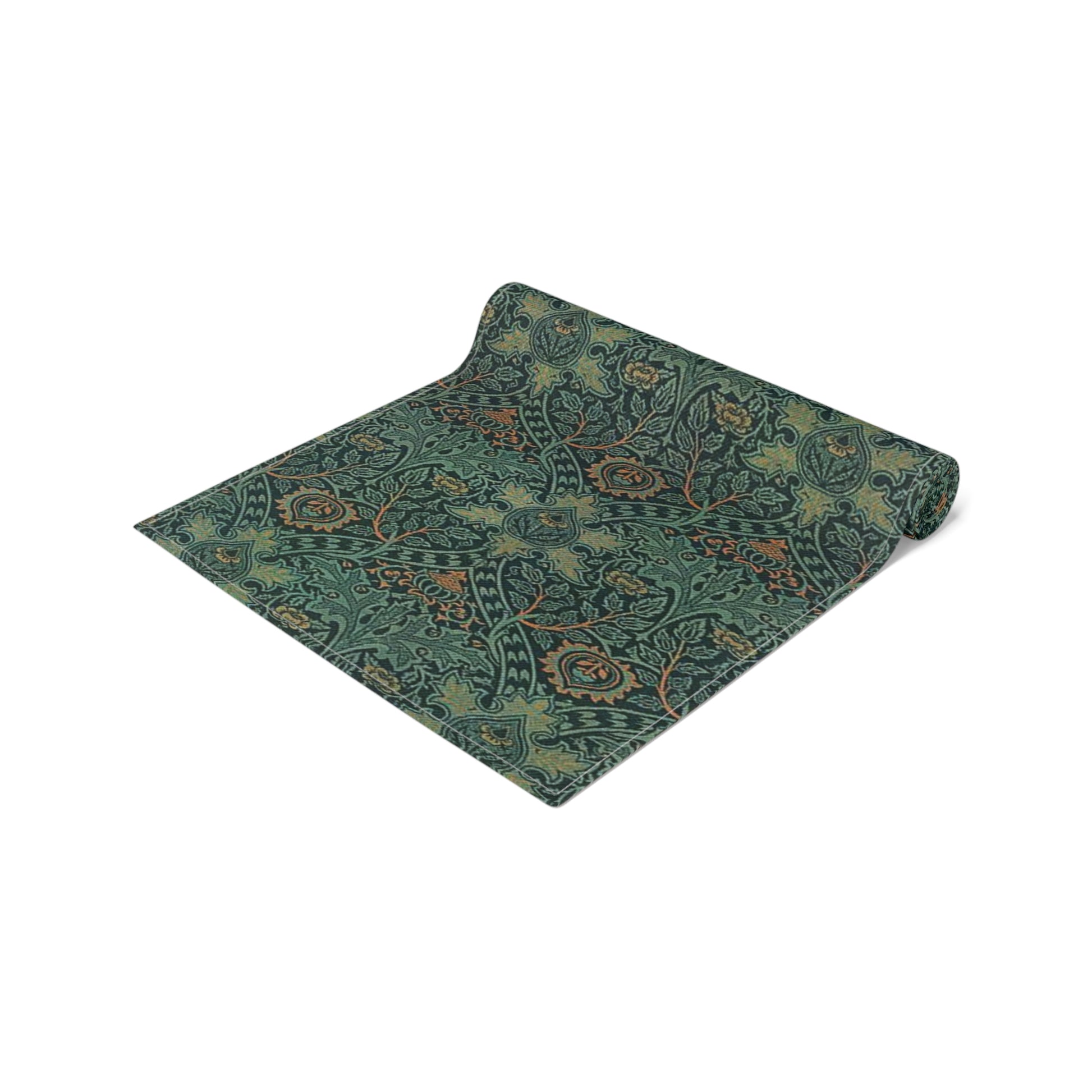 A green table runner with a floral pattern inspired by William Morris, displayed on a dining table with dishes and cutlery.