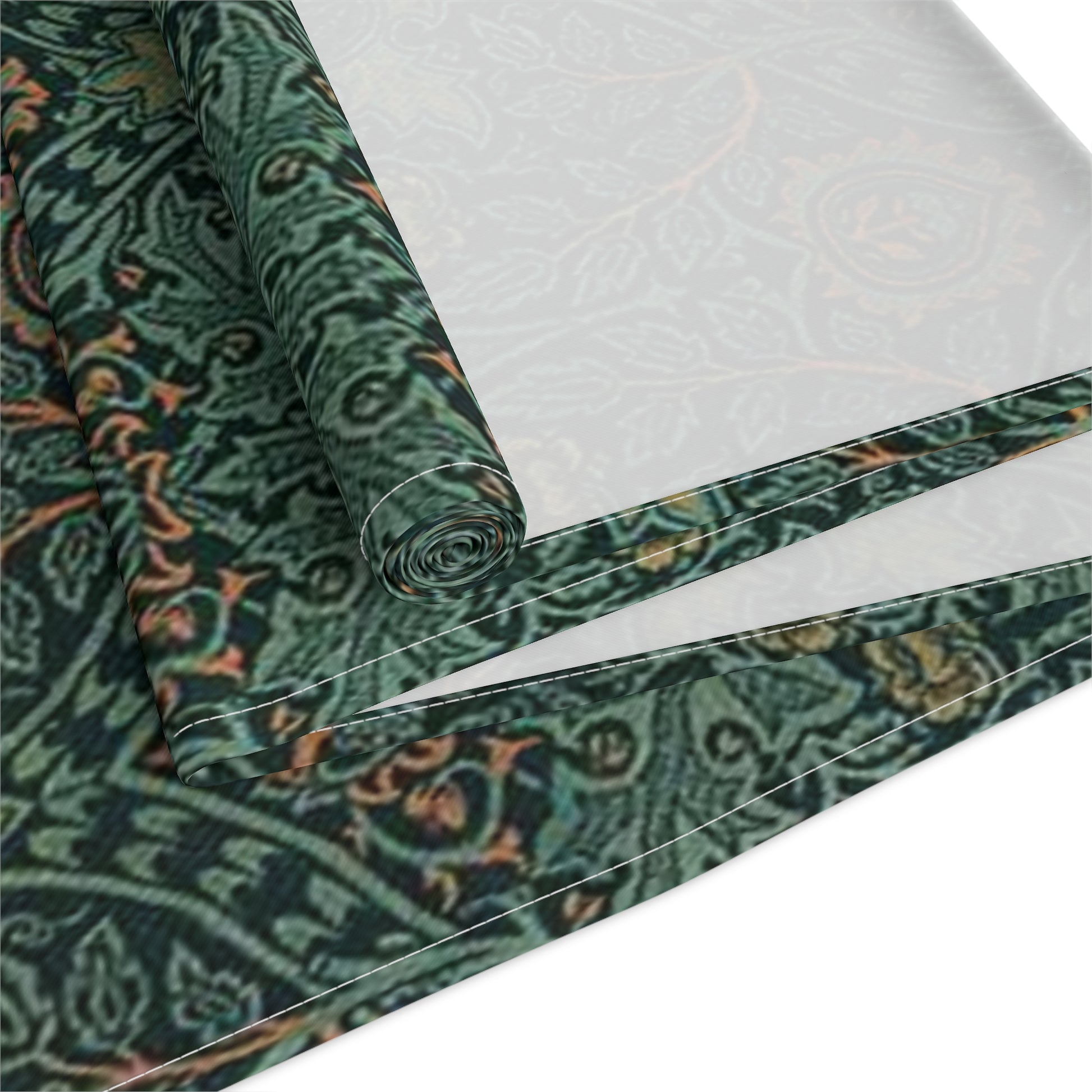 A green table runner with a floral pattern inspired by William Morris, displayed on a dining table with dishes and cutlery.
