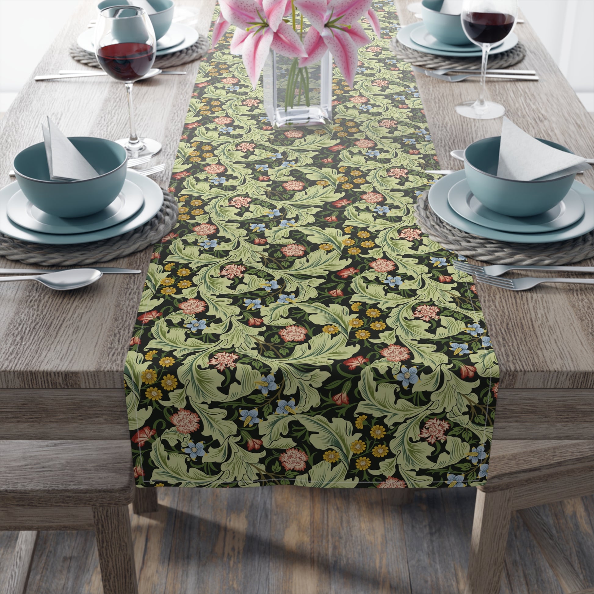 A green floral patterned table runner by William Morris & Co, Leicester Collection, displayed on a dining table.