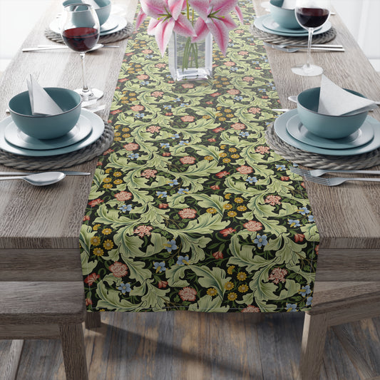 A green floral patterned table runner by William Morris & Co, Leicester Collection, displayed on a dining table.