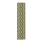 A green floral patterned table runner by William Morris & Co, Leicester Collection, displayed on a dining table.