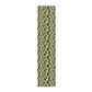 A green floral patterned table runner by William Morris & Co, Leicester Collection, displayed on a dining table.