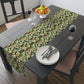 A green floral patterned table runner by William Morris & Co, Leicester Collection, displayed on a dining table.