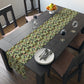A green floral patterned table runner by William Morris & Co, Leicester Collection, displayed on a dining table.