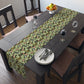 A green floral patterned table runner by William Morris & Co, Leicester Collection, displayed on a dining table.