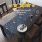 A table runner with a floral pattern in shades of red and blue, displayed on a dining table.