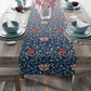A table runner with a floral pattern in shades of red and blue, displayed on a dining table.