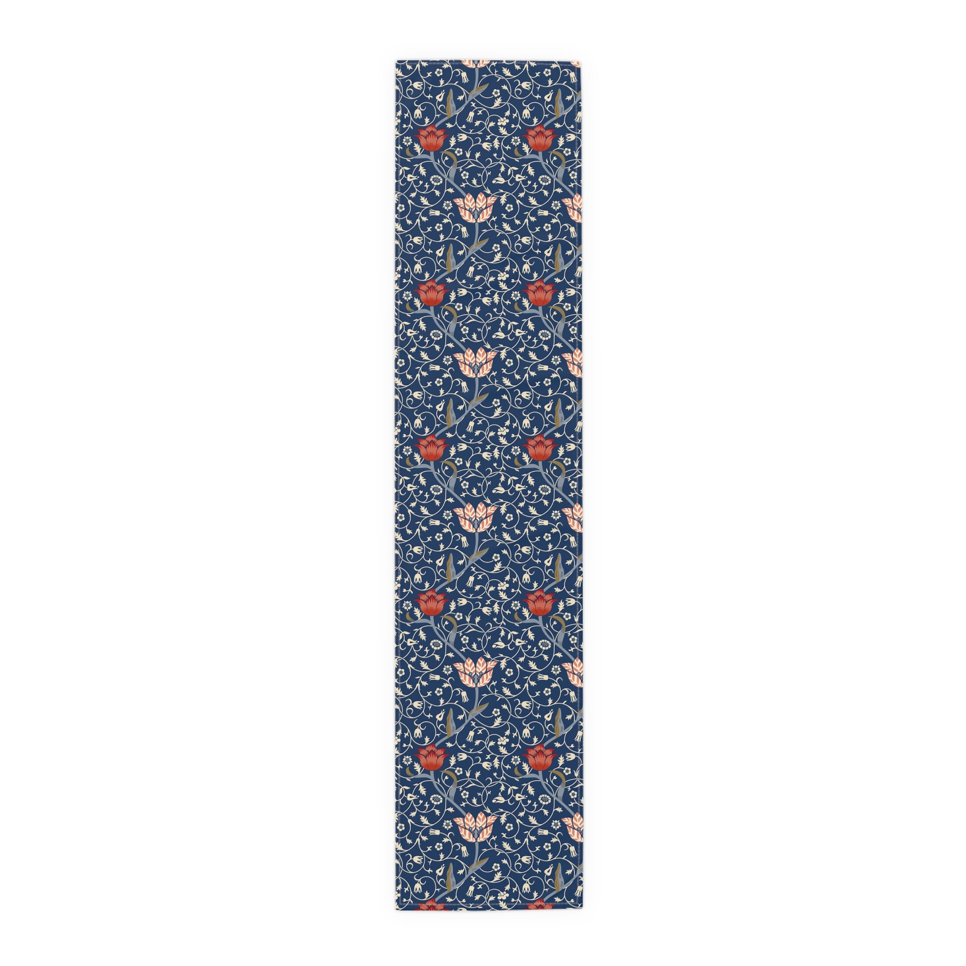 A William Morris & Co table runner with a floral pattern  called Medway in shades of red and blue, displayed on a dining table.
