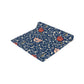 A William Morris & Co table runner with a floral pattern  called Medway in shades of red and blue, displayed on a dining table.