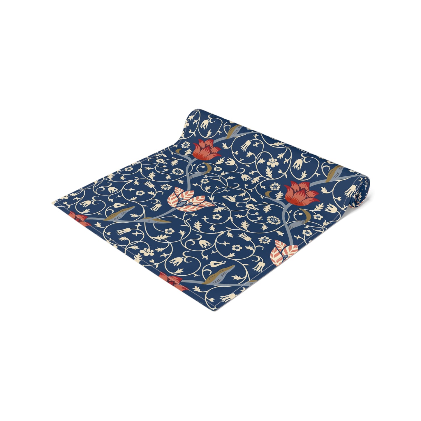 A William Morris & Co table runner with a floral pattern  called Medway in shades of red and blue, displayed on a dining table.