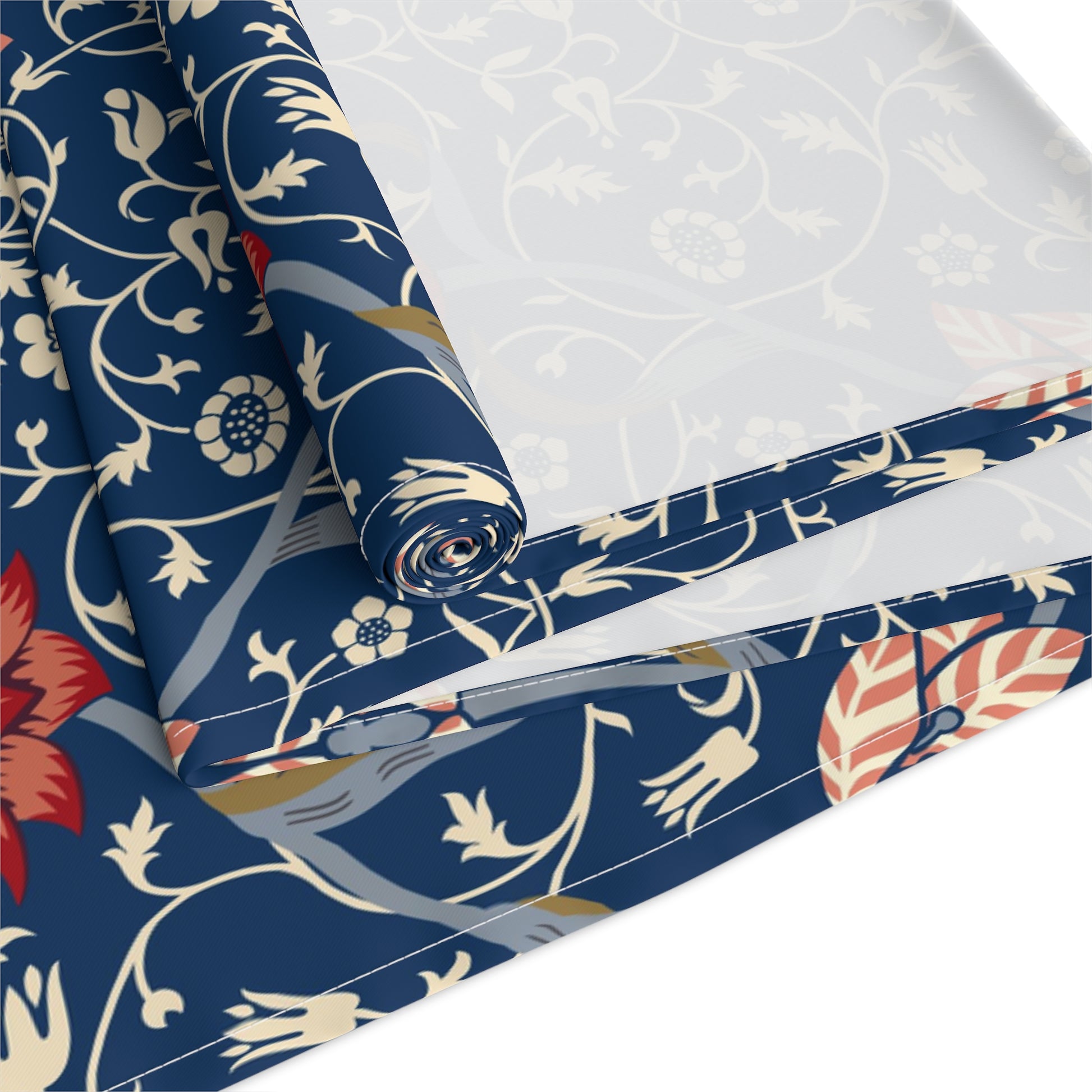 A William Morris & Co table runner with a floral pattern  called Medway in shades of red and blue, displayed on a dining table.