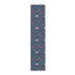 A William Morris & Co table runner with a floral pattern  called Medway in shades of red and blue, displayed on a dining table.