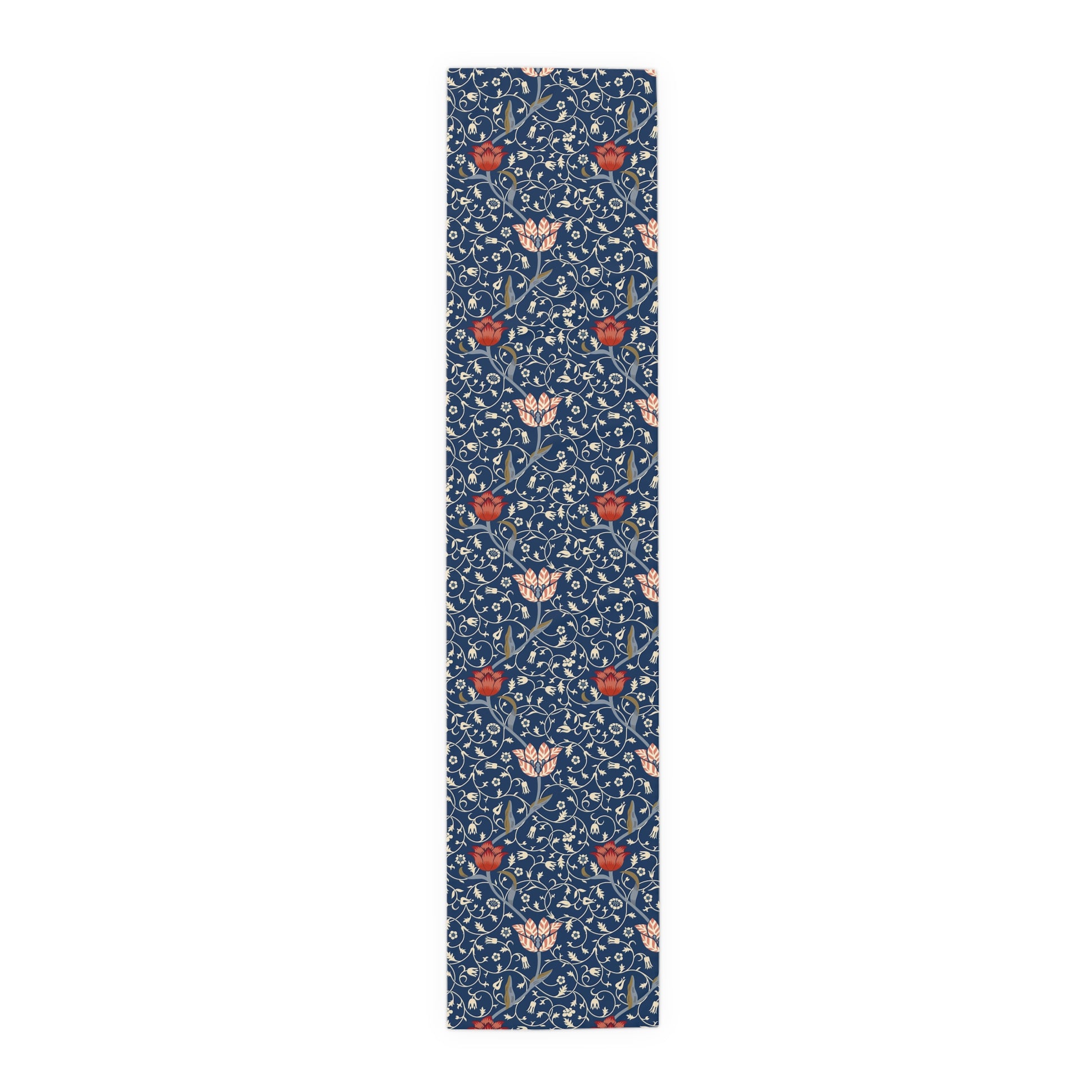 A William Morris & Co table runner with a floral pattern  called Medway in shades of red and blue, displayed on a dining table.