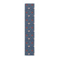 A William Morris & Co table runner with a floral pattern  called Medway in shades of red and blue, displayed on a dining table.