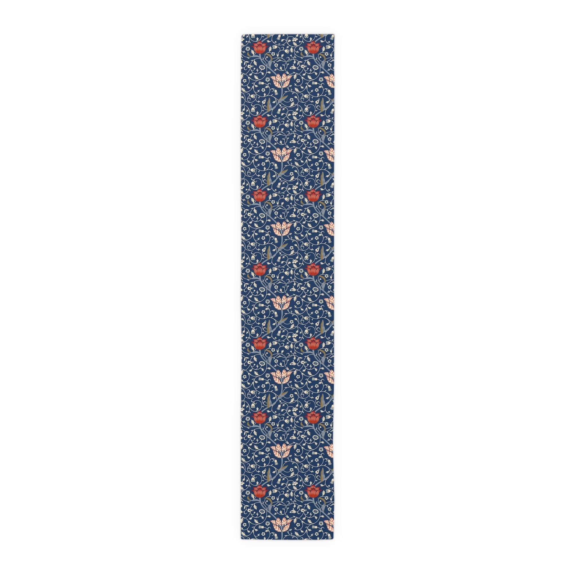 A William Morris & Co table runner with a floral pattern  called Medway in shades of red and blue, displayed on a dining table.