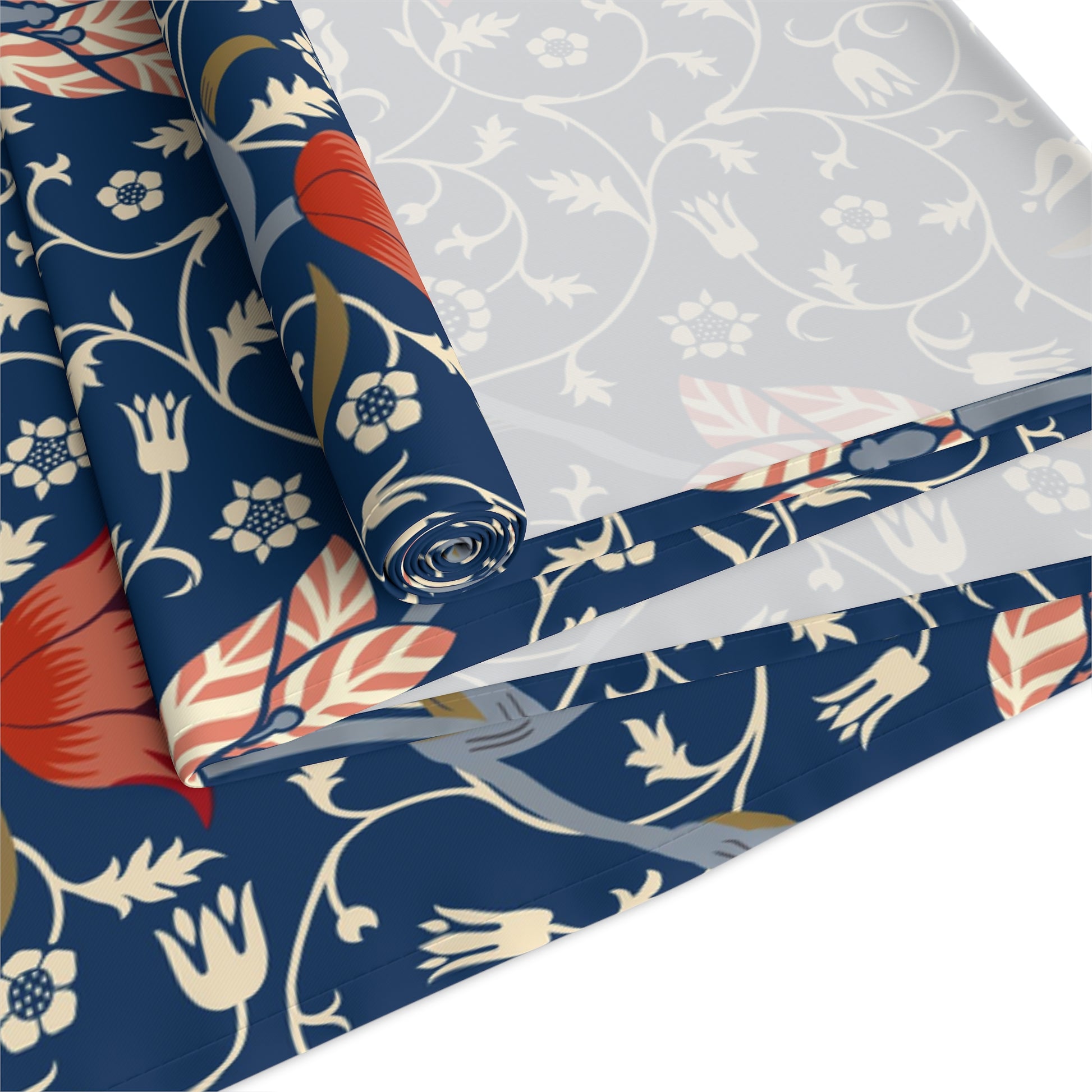 A William Morris & Co table runner with a floral pattern  called Medway in shades of red and blue, displayed on a dining table.