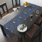 A William Morris & Co table runner with a floral pattern  called Medway in shades of red and blue, displayed on a dining table.