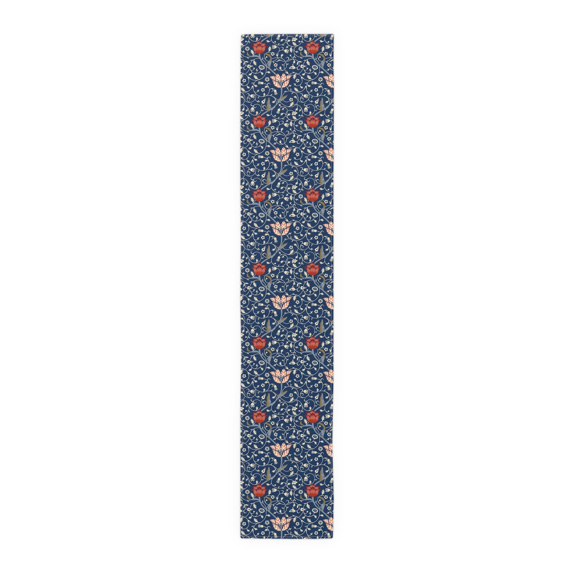 A William Morris & Co table runner with a floral pattern  called Medway in shades of red and blue, displayed on a dining table.