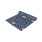 A William Morris & Co table runner with a floral pattern  called Medway in shades of red and blue, displayed on a dining table.