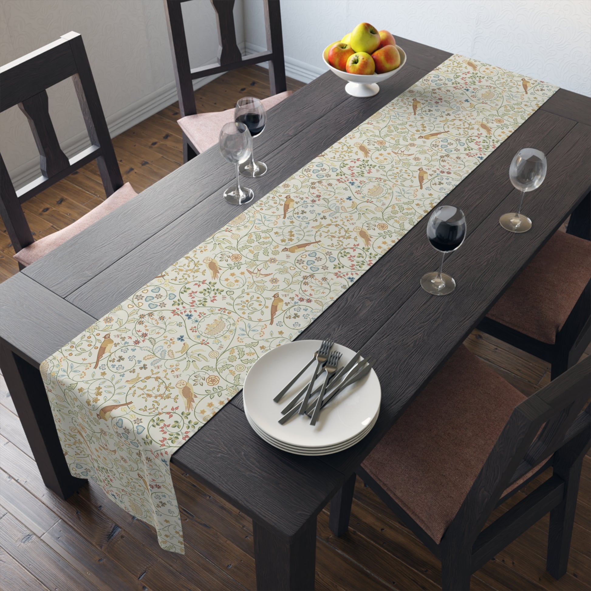 Dining table with a floral-patterned table runner, plates, and glasses.