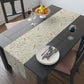 Table setting with a floral-patterned table runner on a wooden table.