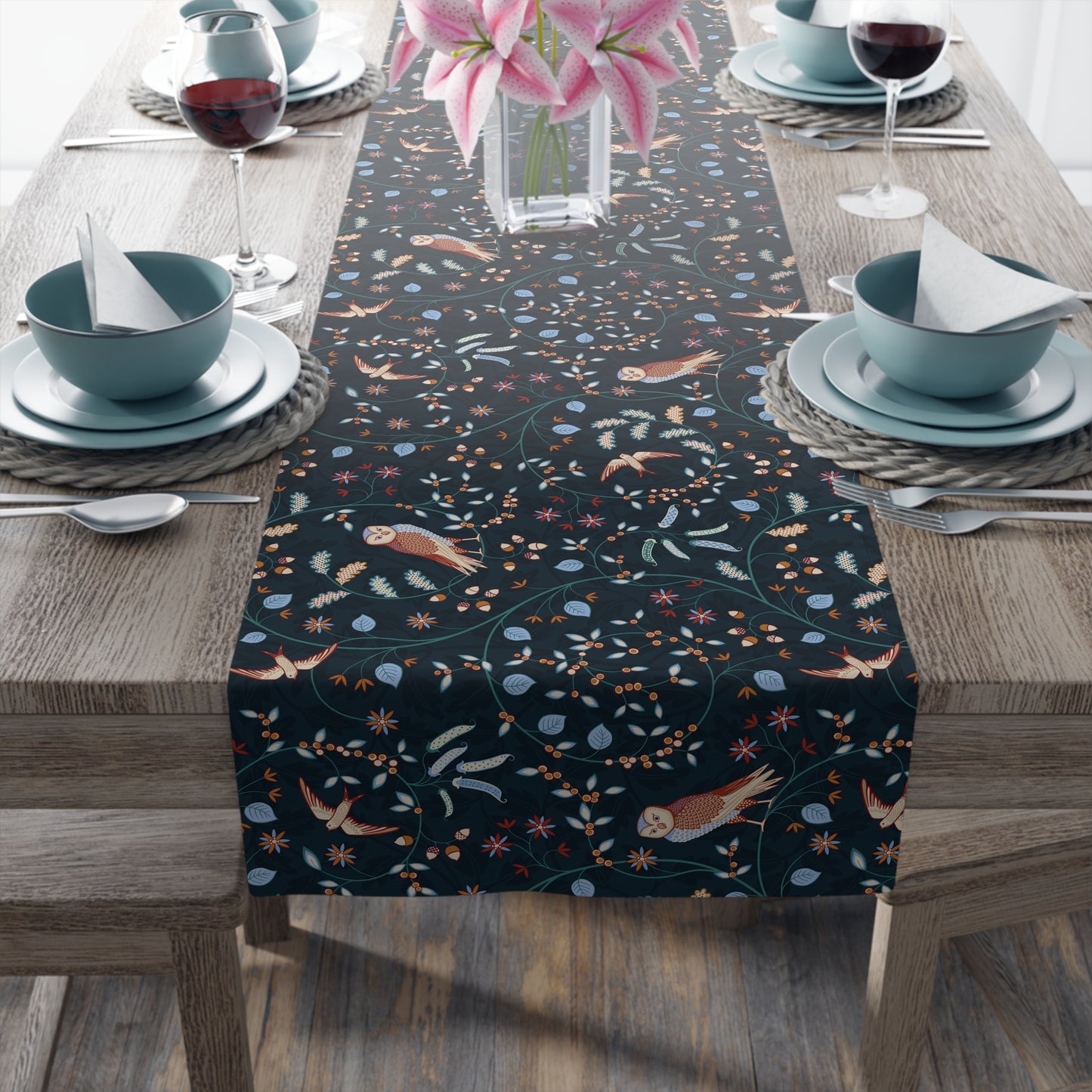 Table runner with nature-themed design on a wooden table with place settings.