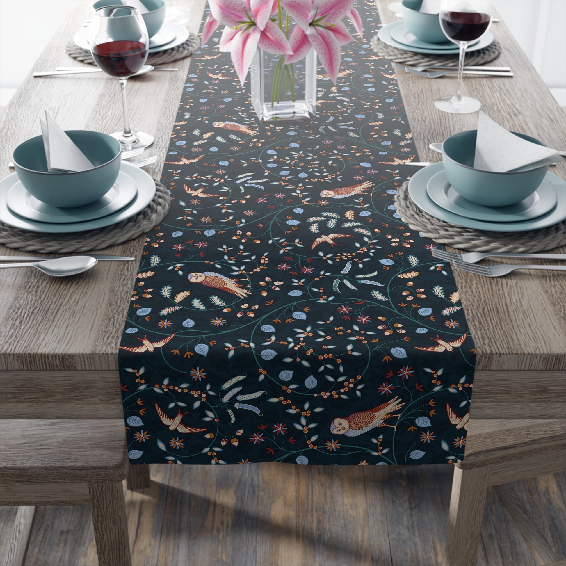 Table runner with nature-themed design on a wooden table with place settings.