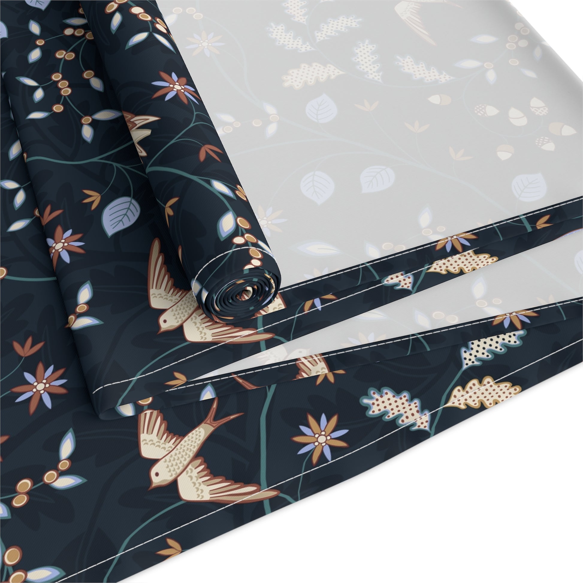 Rolls of fabric with bird and floral pattern on a white background