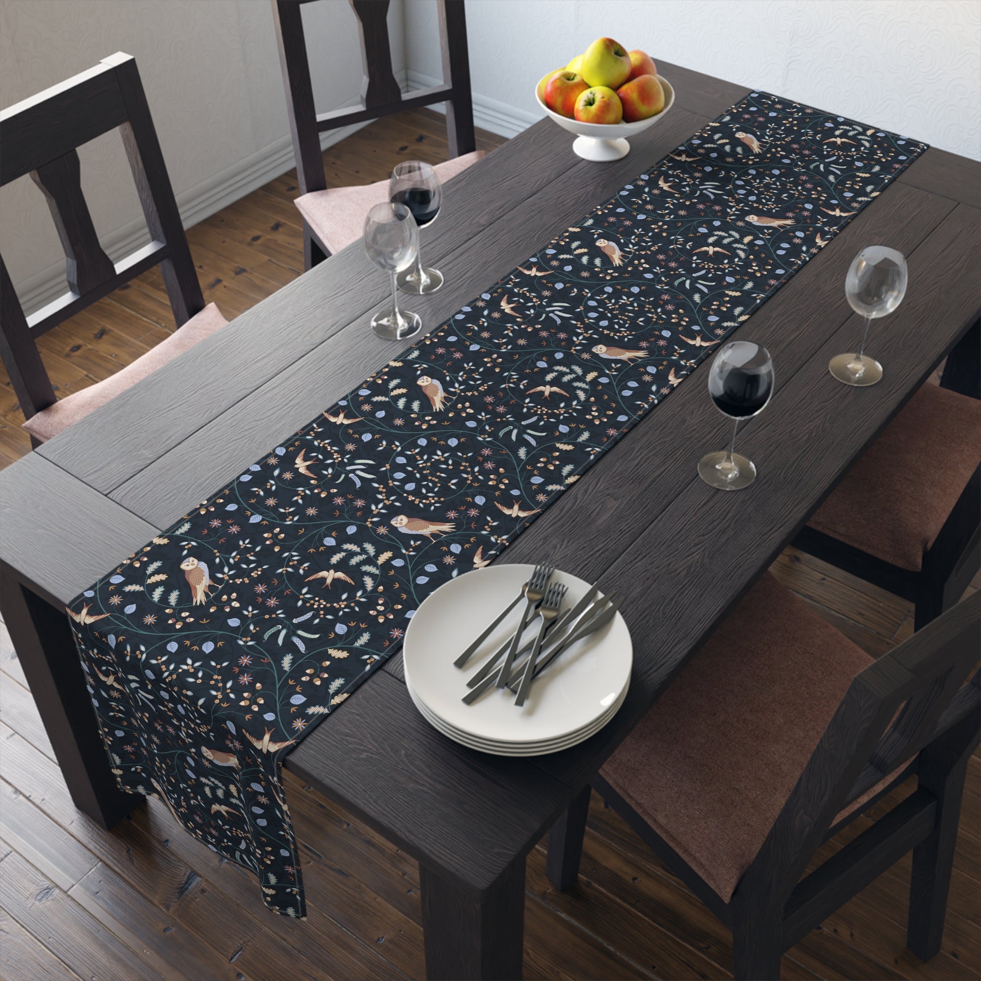 Dining table with a patterned table runner, plates, and glasses in a room.