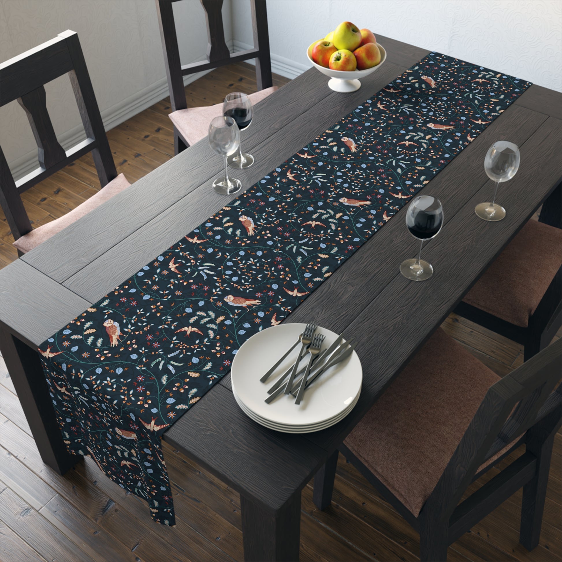 Dining table with a patterned table runner, plates, and glasses in a room.