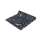Rolled-up table runner with nature-themed design on a white background