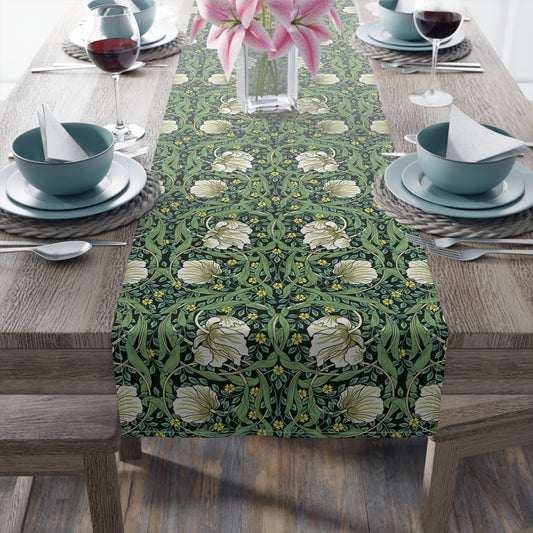 A green table runner with a floral William Morris & Co pattern displayed on a dining table.