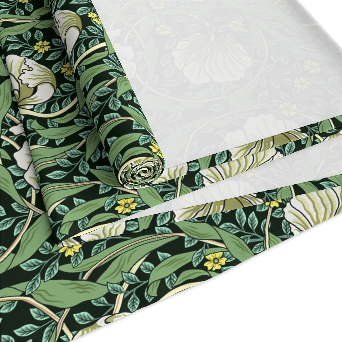 A green table runner with a floral William Morris & Co pattern displayed on a dining table.