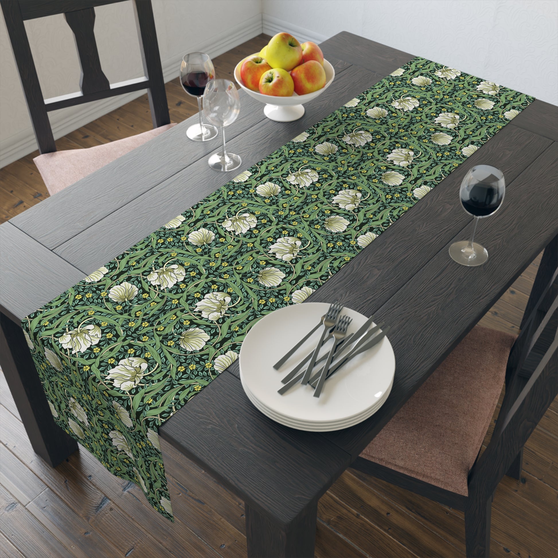 A green table runner with a floral William Morris & Co pattern displayed on a dining table.
