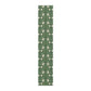 A green table runner with a floral William Morris & Co pattern displayed on a dining table.