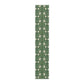 A green table runner with a floral William Morris & Co pattern displayed on a dining table.