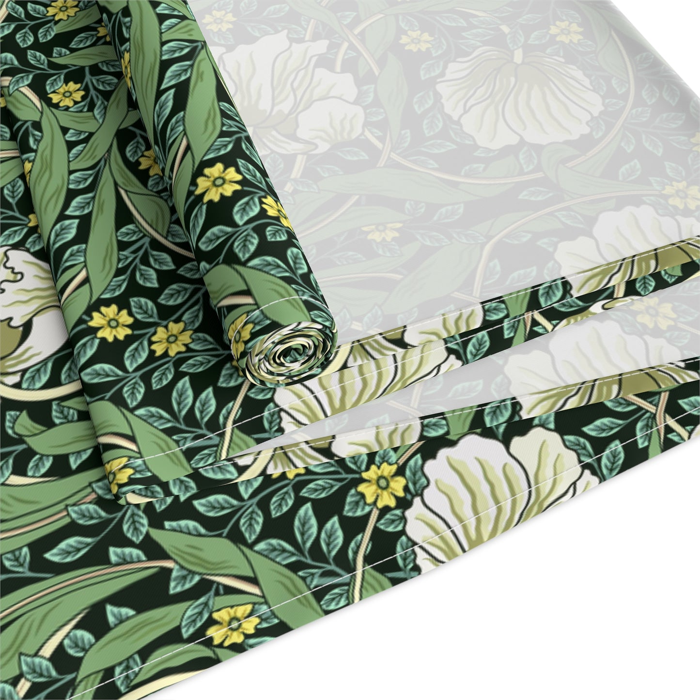 A green table runner with a floral William Morris & Co pattern displayed on a dining table.