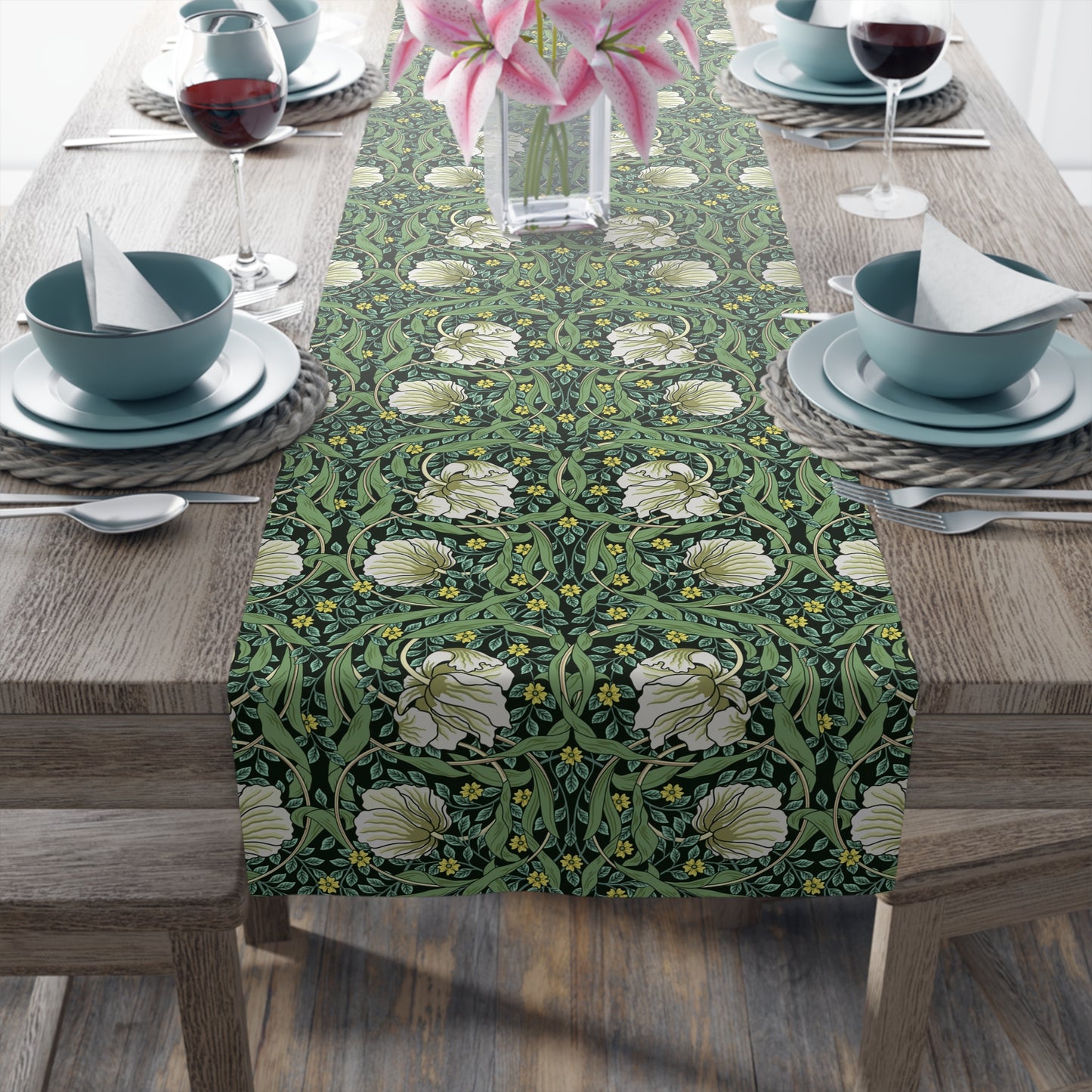 A green table runner with a floral William Morris & Co pattern displayed on a dining table.