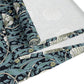 A table runner with a floral William Morris & Co pattern in slate colour laid out on a dining table.