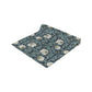 A table runner with a floral William Morris & Co pattern in slate colour laid out on a dining table.