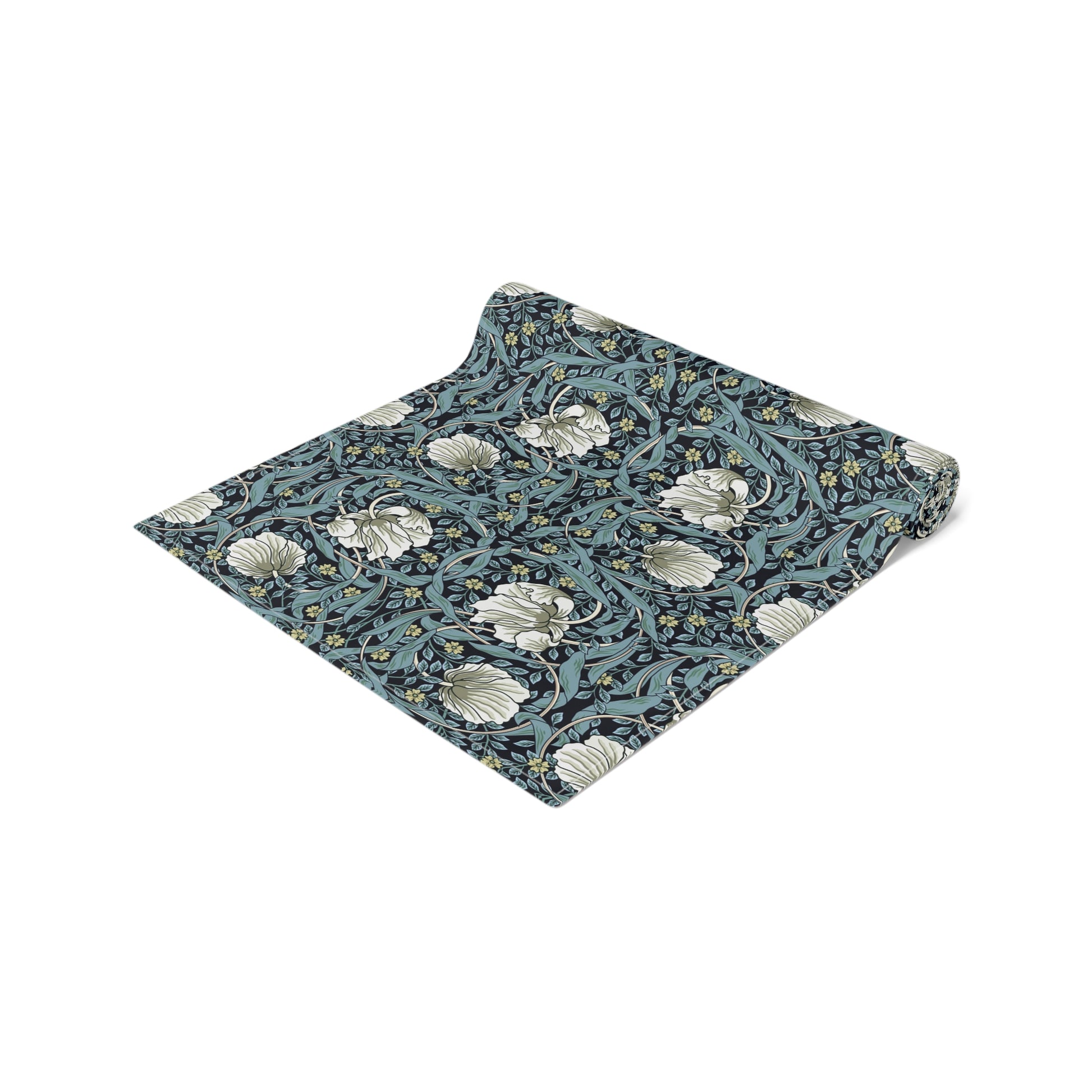 A table runner with a floral William Morris & Co pattern in slate colour laid out on a dining table.