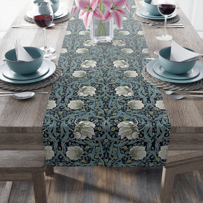 A table runner with a floral pattern in slate color laid out on a dining table.