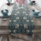 A table runner with a floral pattern in slate color laid out on a dining table.