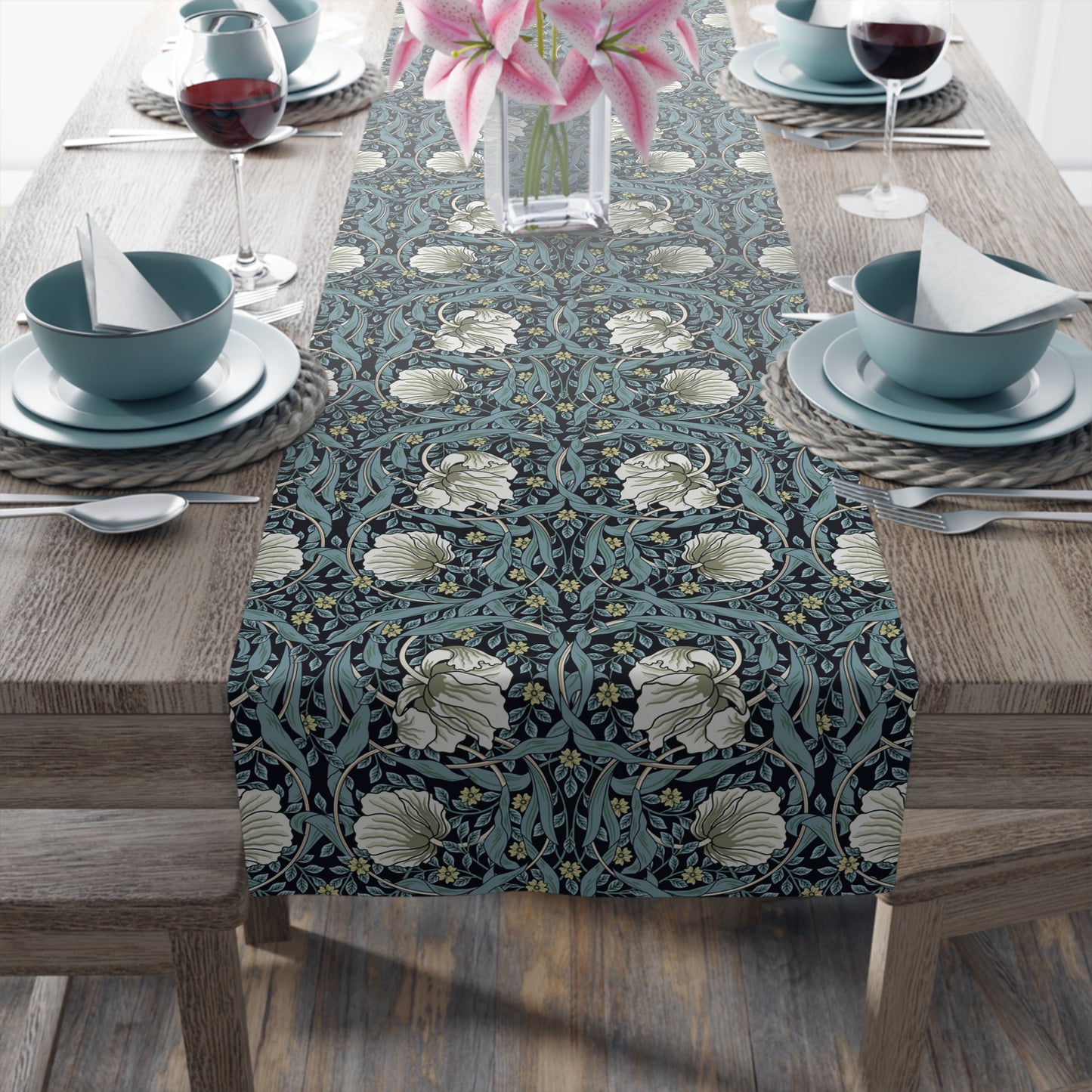 A table runner with a floral pattern in slate color laid out on a dining table.