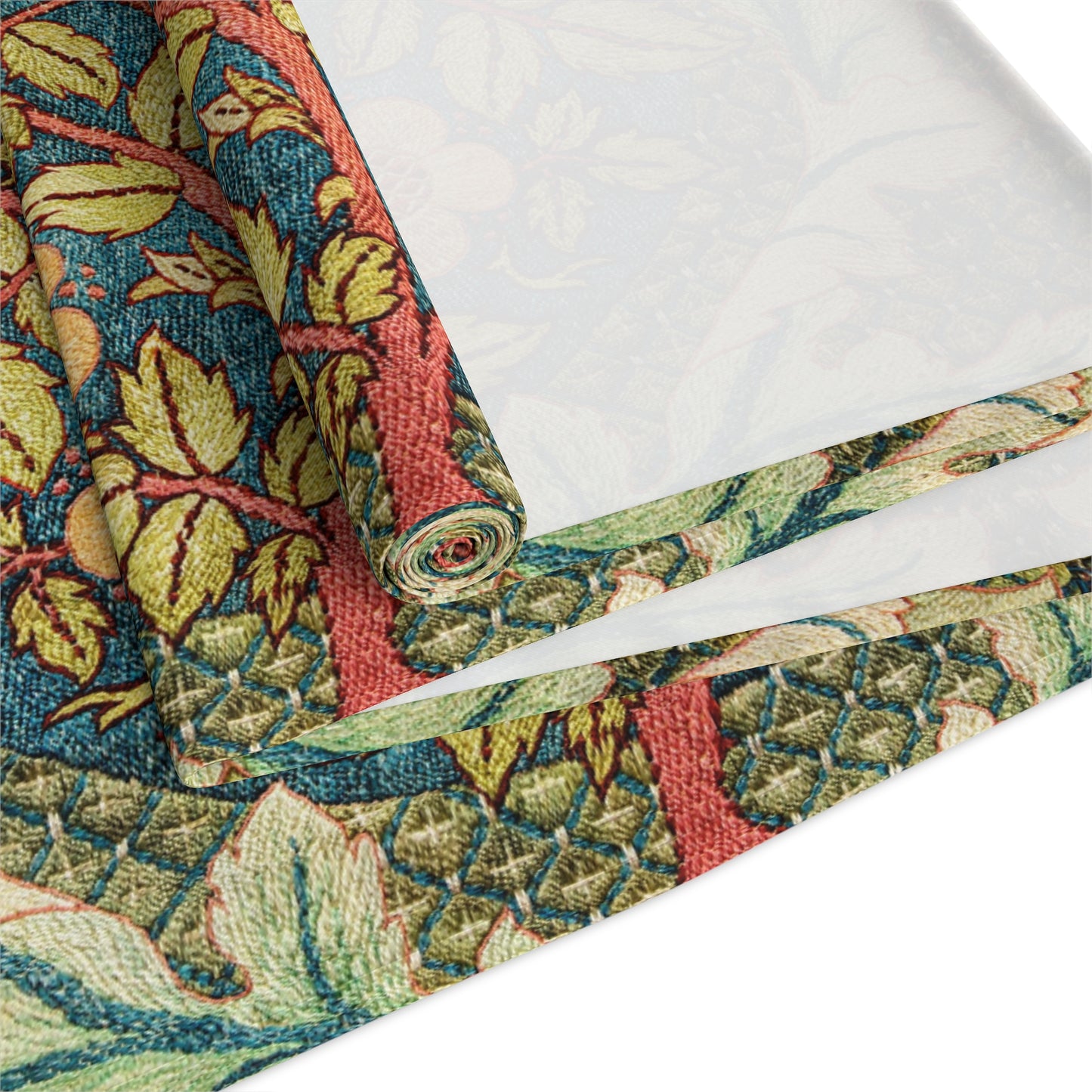 A table runner with a floral pattern inspired by William Morris, displayed on a dining table set with dishes and glasses.